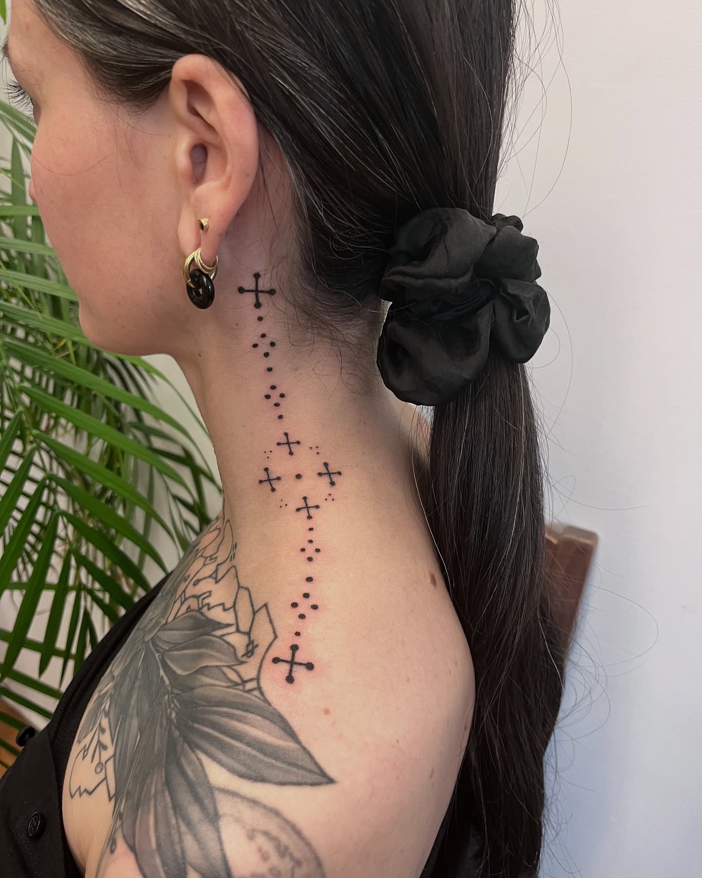 Tatouage handpoke symbolique sur le cou, croix en pointillé