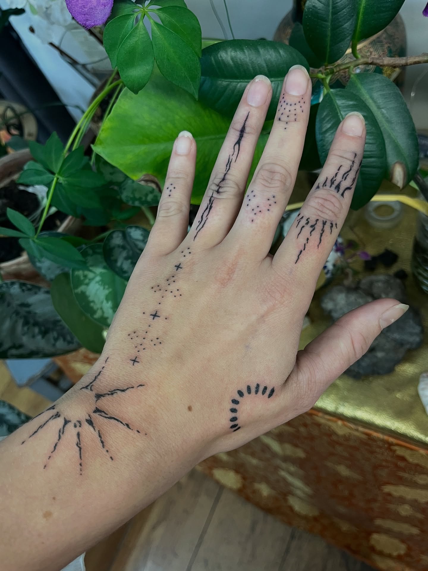 Tatouage handpoke ornemental sur la main, motif rayonnant