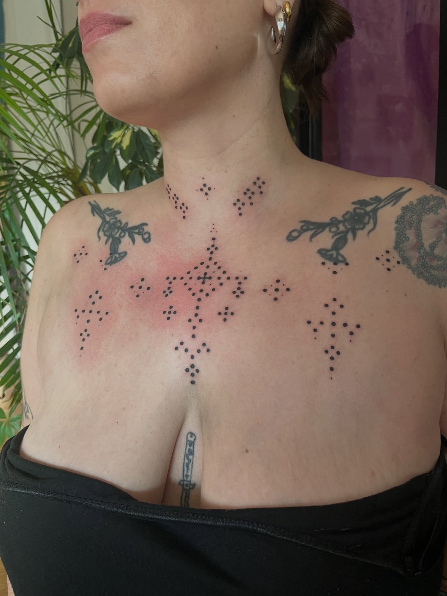 Tatouage handpoke ornemental sur le décolleté, dotwork