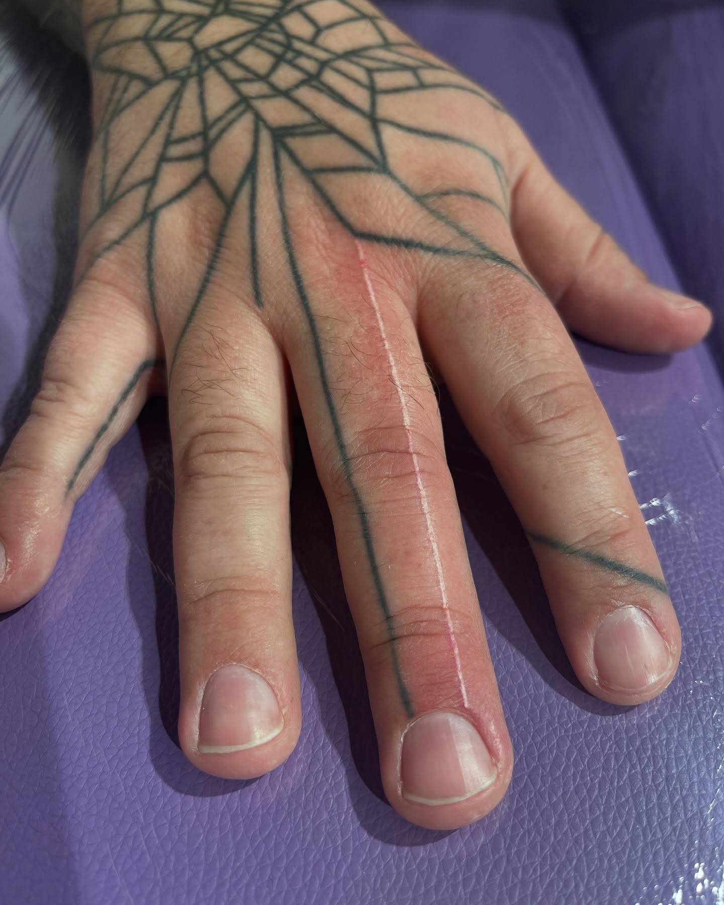 Tatouage handpoke lignes géométriques sur la main